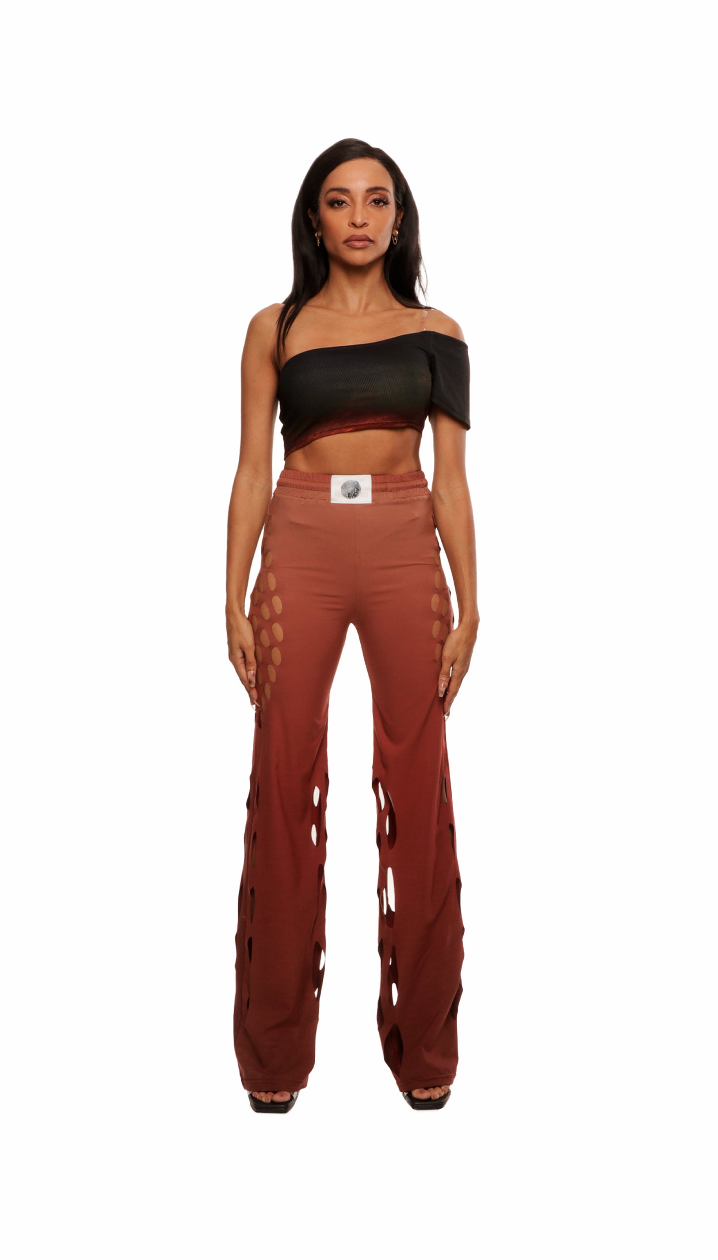 Woman who looks like Beyoncé or Aaliyah wears gradient brown toned bottoms or pants with cutout details on the sides, front view