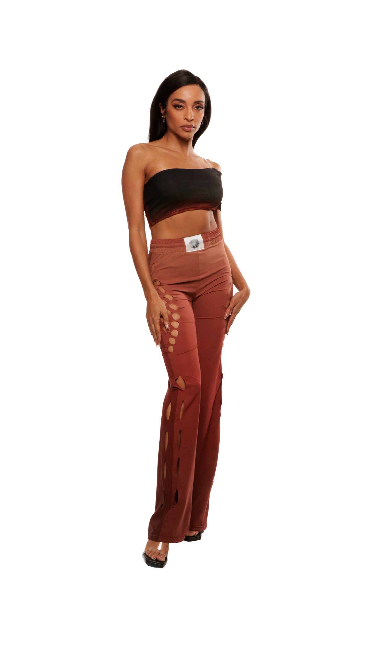 Woman who looks like Beyoncé or Aaliyah wears gradient brown toned bottoms or pants with cutout details on the sides, front view